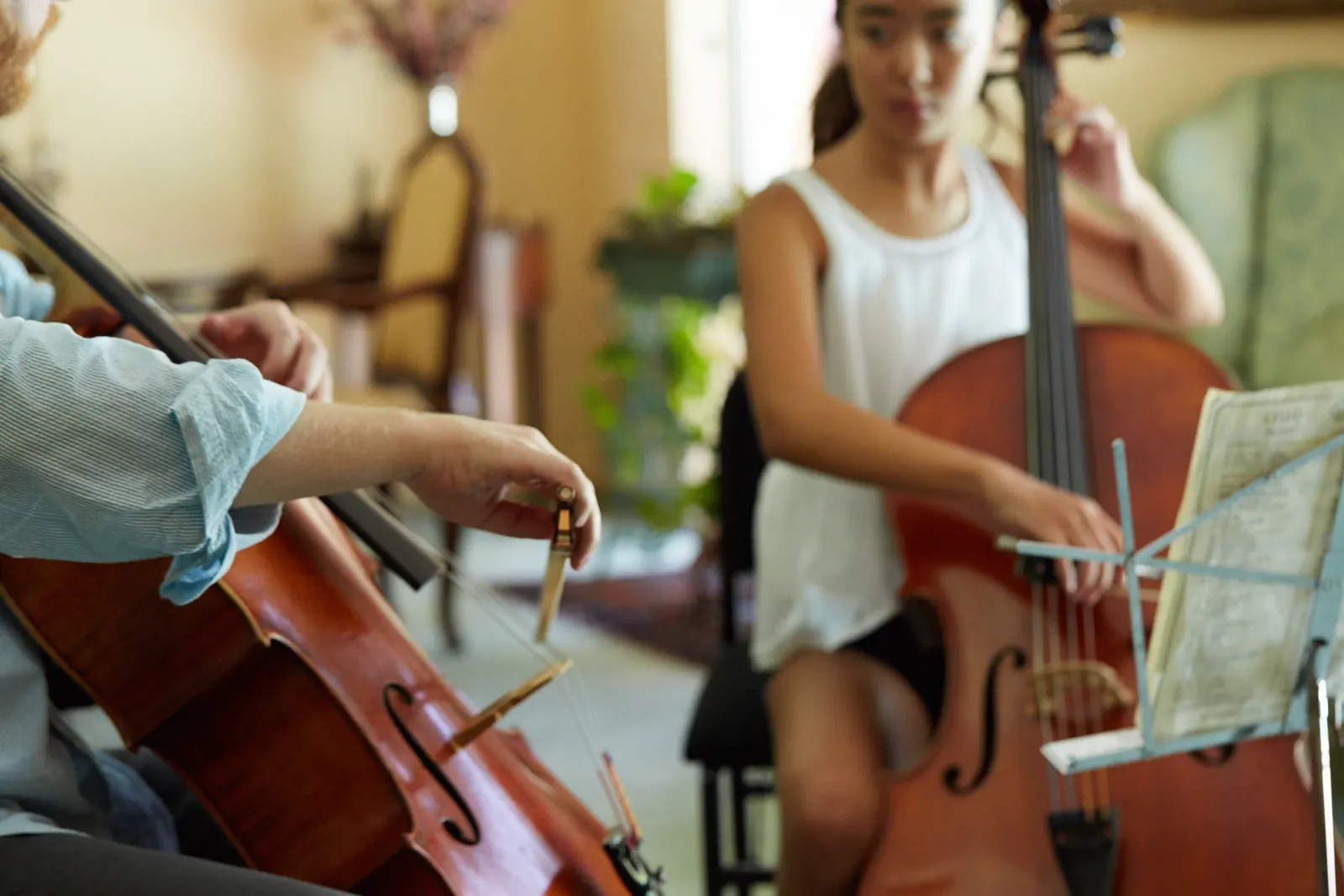 Teen cellist playing during a lesson